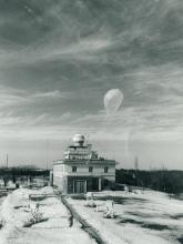 Moment wypuszczenia sondy aerologicznej. W tle budynek Zakładu Aerologii z zamontowanym na dachu radarem MRŁ-2 (zdjęcie z 1976 roku, archiwum IMGW-PIB).Moment wypuszczenia sondy aerologicznej. W tle budynek Zakładu Aerologii z zamontowanym na dachu radarem MRŁ-2 (zdjęcie z 1976 roku, archiwum IMGW-PIB).