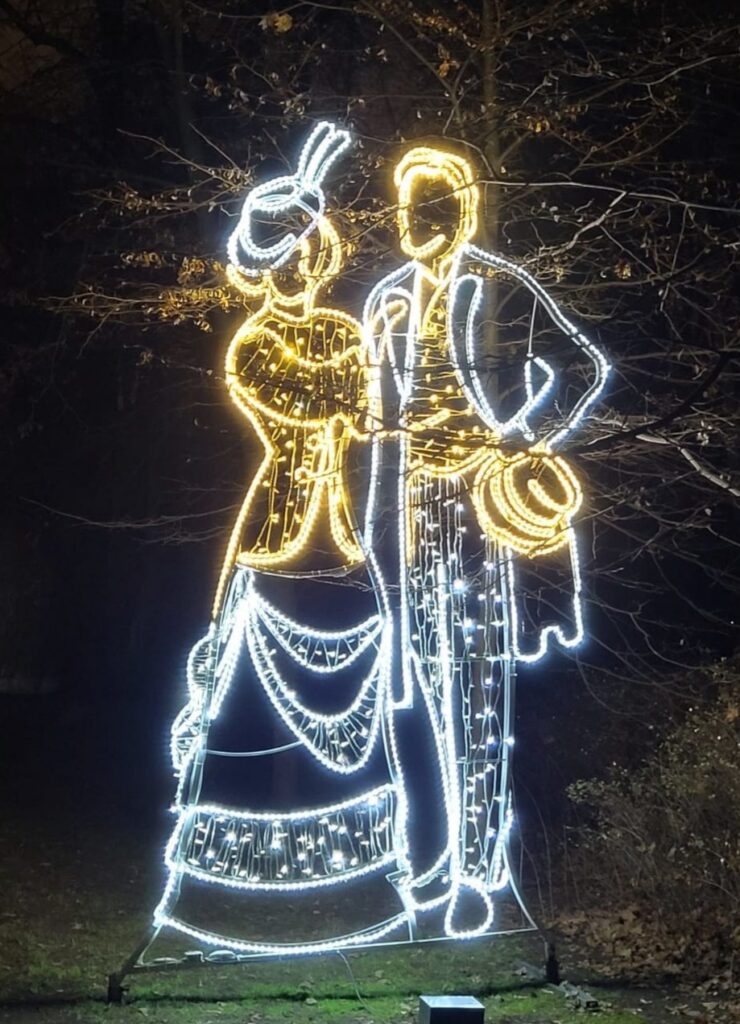 Zdjęcie dekoracji świetlnej przedstawiające kobietę i mężczyznę w strojach z minionej epoki Zdjęcie dekoracji świetlnej przedstawiające kobietę i mężczyznę w strojach z minionej epoki